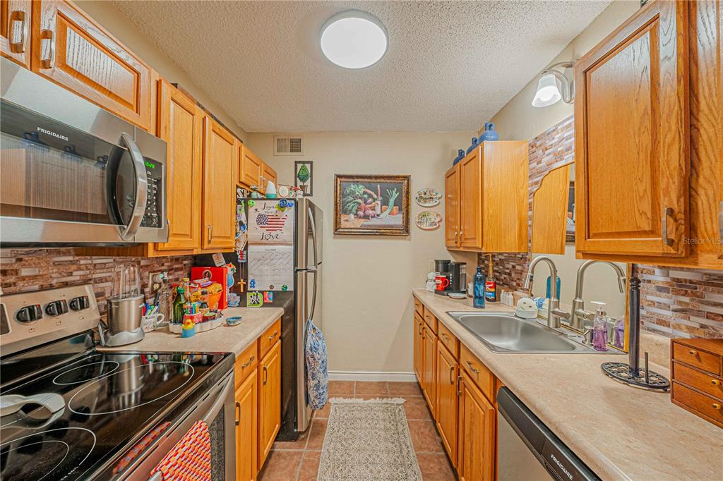 2418 Northeast 7th Street, Unit 6 Ocala, FL 34470 - Photo 15 of 39 a kitchen with stainless steel appliances a stove a sink dishwasher and cabinets with wooden floor