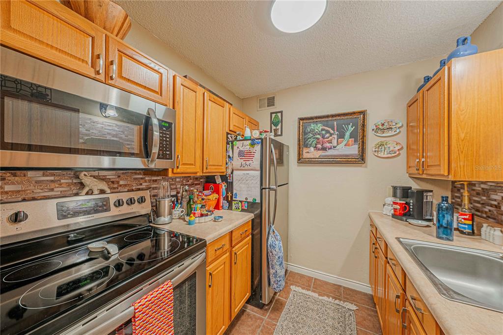 2418 Northeast 7th Street, Unit 6 Ocala, FL 34470 - Photo 16 of 39 a kitchen with stainless steel appliances a stove and a refrigerator