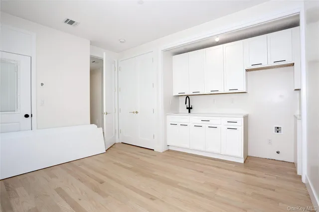 a kitchen with white cabinets and white appliances