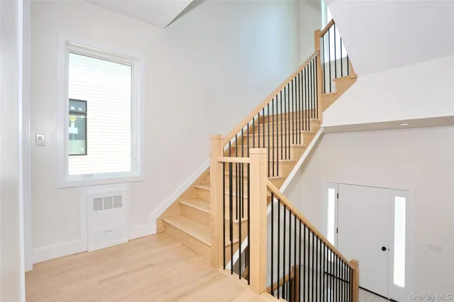 a view of staircase with wooden floor and white walls