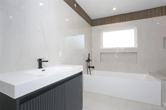 a bathroom with a sink a bathtub and a mirror