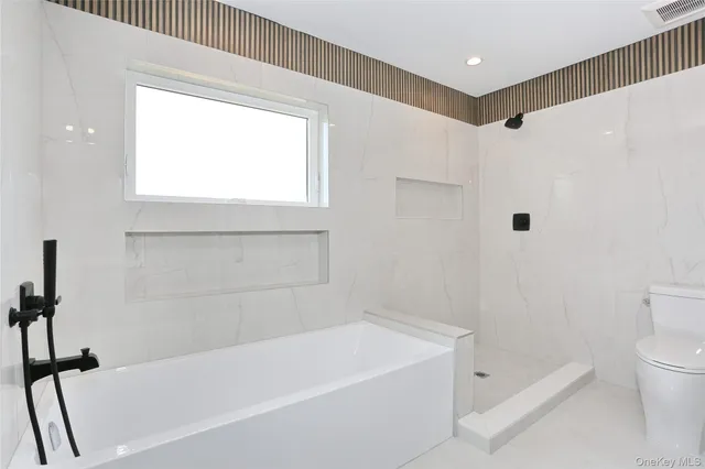 a bathroom with a bathtub a toilet and a shower