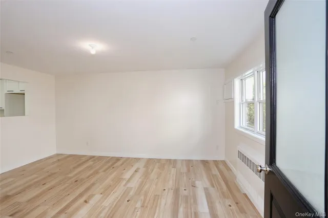 a view of a room that has wooden floor and cabinets