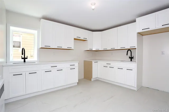 a kitchen with white cabinets and white appliances