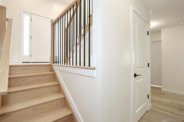 a view of a hallway with wooden floor and staircase