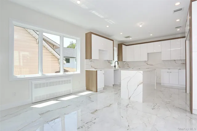 a kitchen with a sink cabinets stainless steel appliances and a window