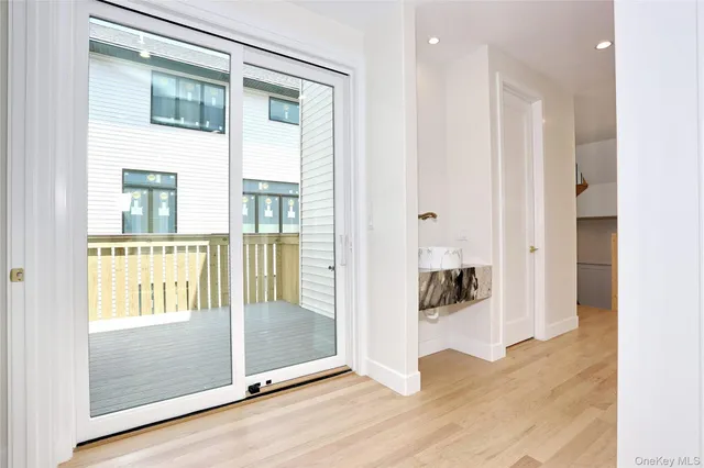 a view of a big room with wooden floor mirror and windows