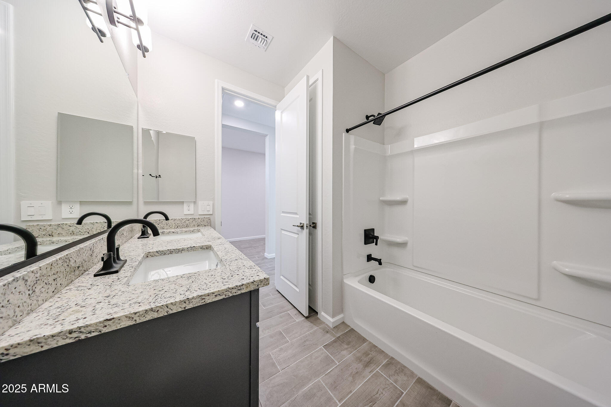 17867 West Fulton Street Goodyear, AZ 85338 - Photo 32 of 40 a bathroom with a granite countertop sink mirror and a bath tub