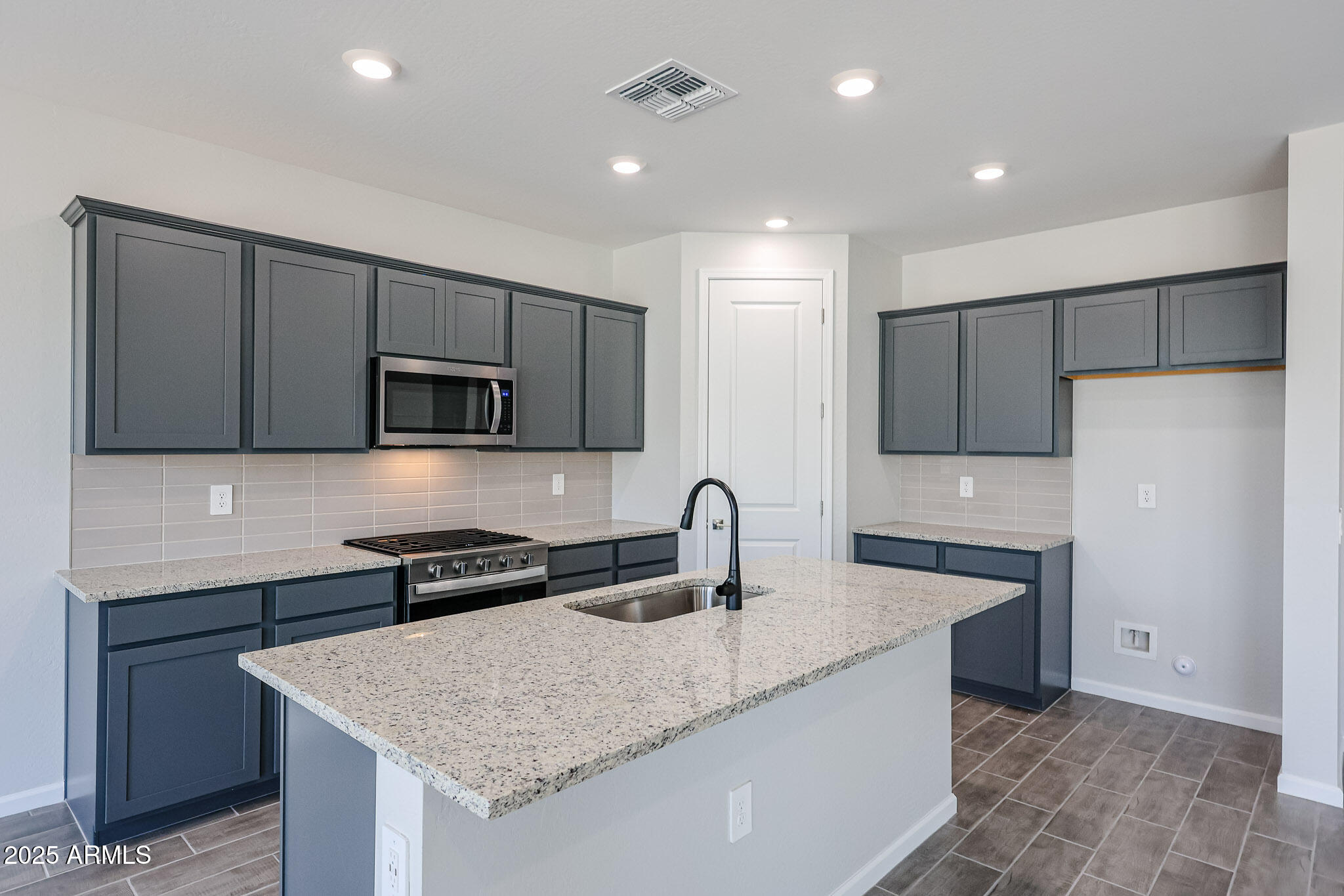 17867 West Fulton Street Goodyear, AZ 85338 - Photo 4 of 40 a kitchen with stainless steel appliances granite countertop a sink and a refrigerator