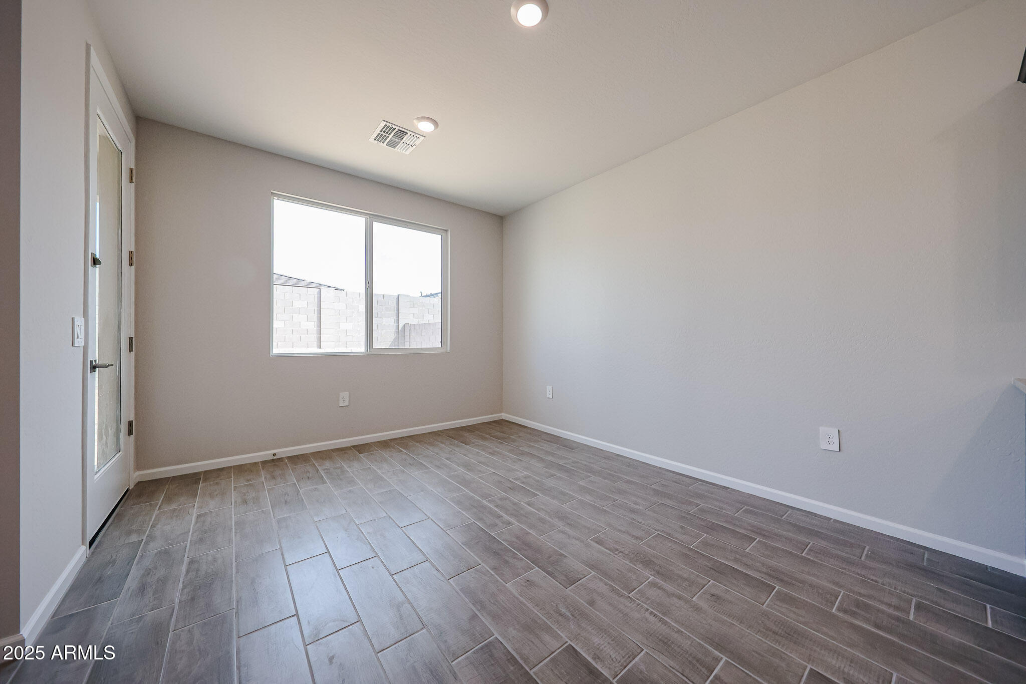 17867 West Fulton Street Goodyear, AZ 85338 - Photo 9 of 40 an empty room with wooden floor and windows