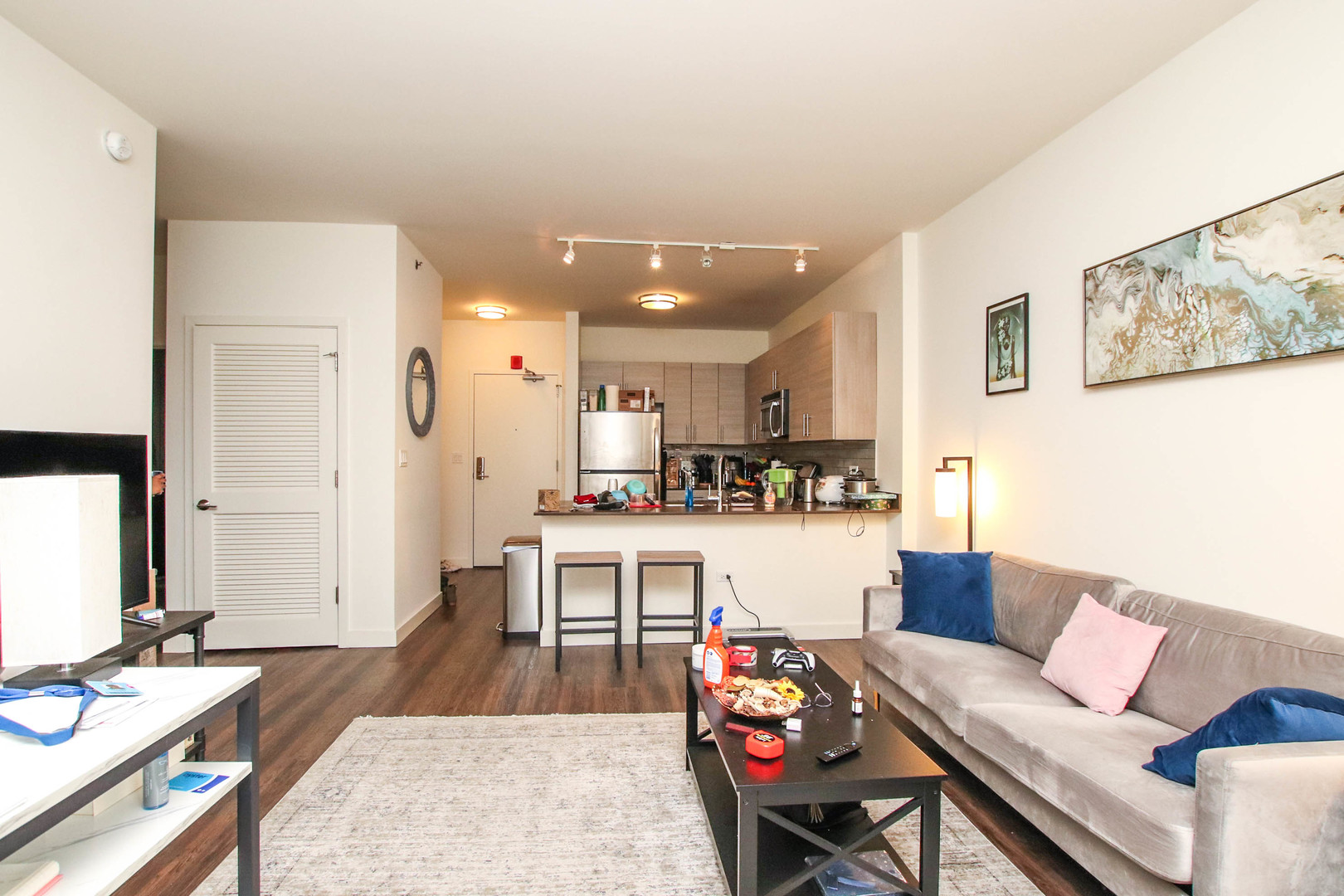 1164 West Madison Street, Unit 309 Chicago, IL 60607 - Photo 4 of 18 a living room with stainless steel appliances kitchen island granite countertop furniture and a wooden floor