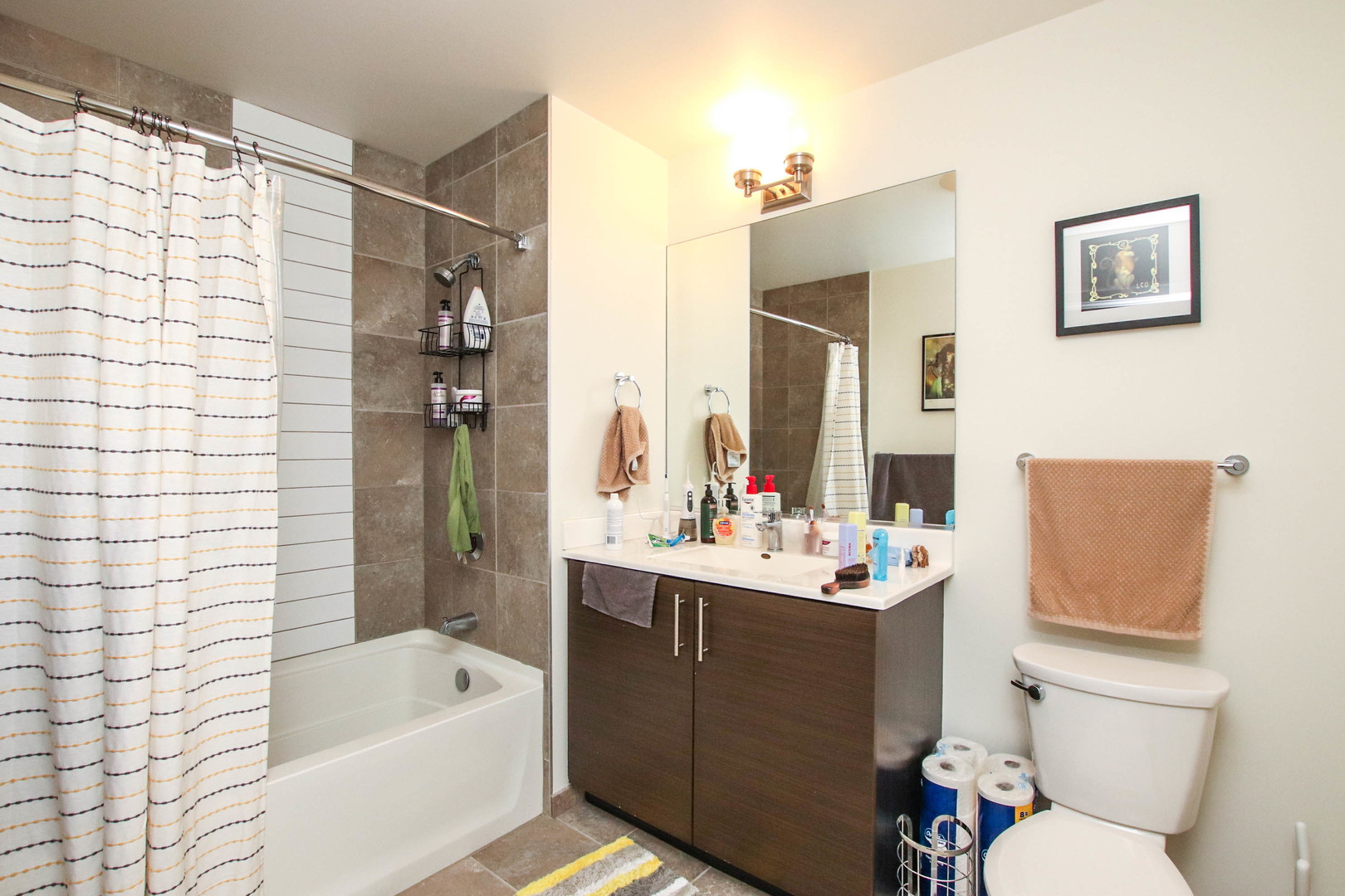 1164 West Madison Street, Unit 309 Chicago, IL 60607 - Photo 7 of 18 a bathroom with a sink toilet tub and shower