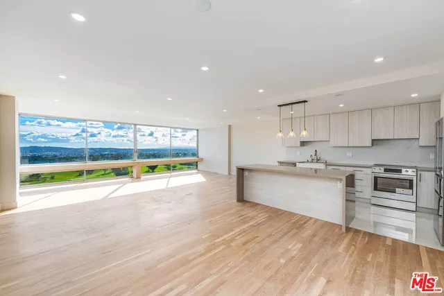 a kitchen with stainless steel appliances granite countertop a stove and a wooden floors