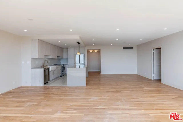 a kitchen with stainless steel appliances kitchen island sink refrigerator and cabinets