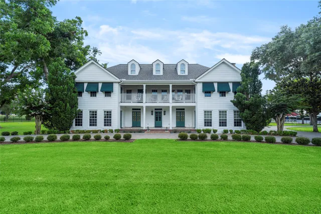 a front view of a house with a garden and trees