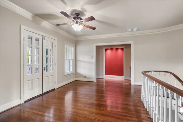 a view of an empty room with window and wooden floor