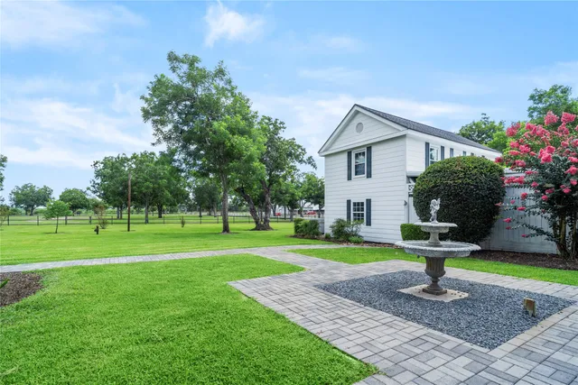 a front view of a house with a yard garage and fountain