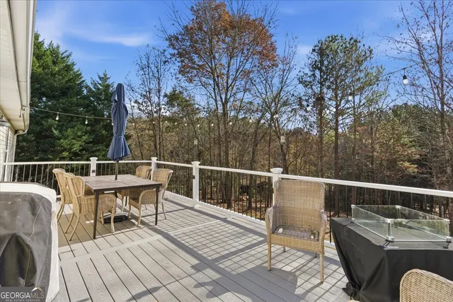 a view of a roof deck with couches wooden floor and fence