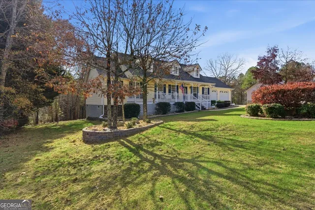 a view of a house with a big yard potted plants and large tree