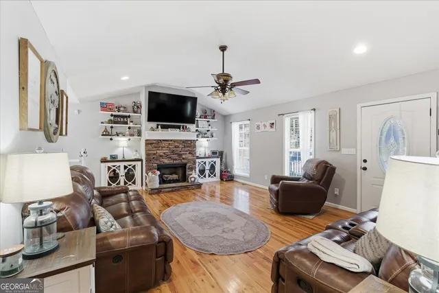 a living room with furniture a flat screen tv and a fireplace
