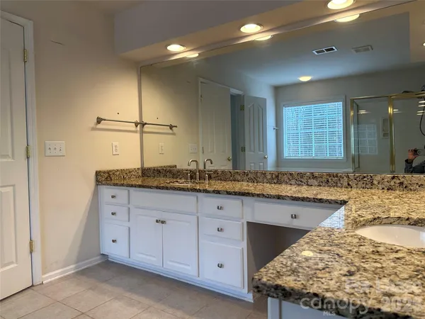 a bathroom with a granite countertop sink and a mirror