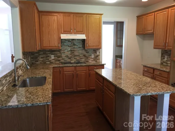 a kitchen with stainless steel appliances granite countertop a refrigerator and a stove