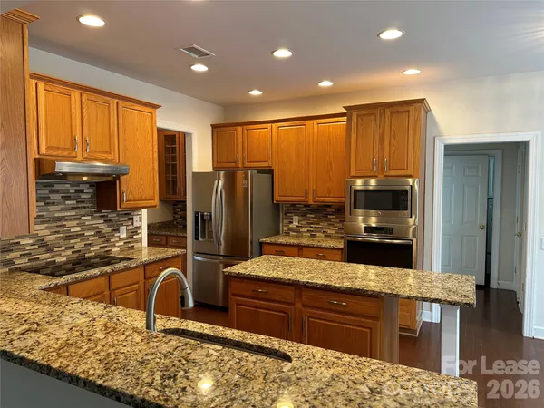 a kitchen with kitchen island granite countertop a sink stove and refrigerator
