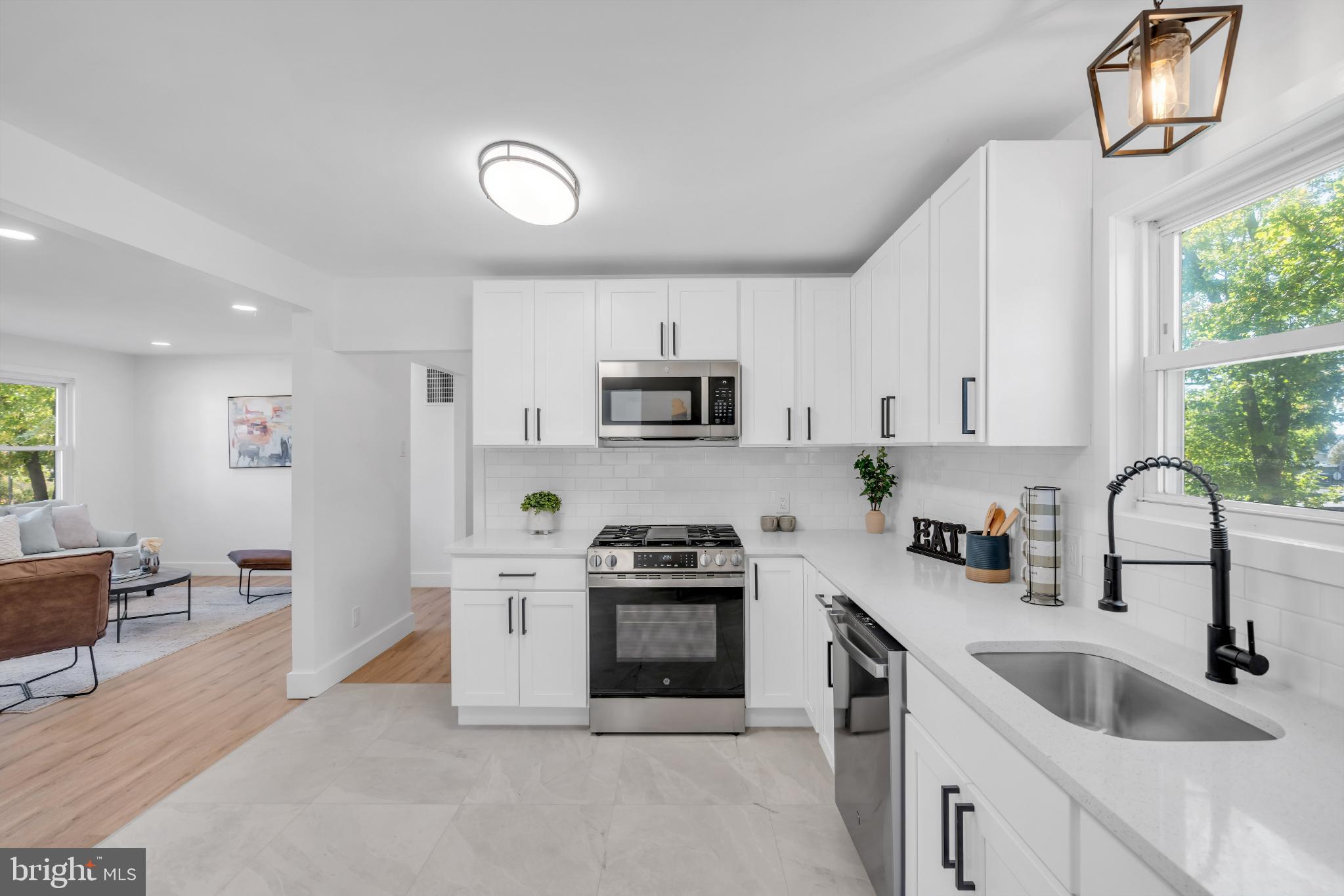 104 East Laurelton Avenue Maple Shade, NJ 08052 - Photo 8 of 37 a kitchen with sink a microwave and cabinets