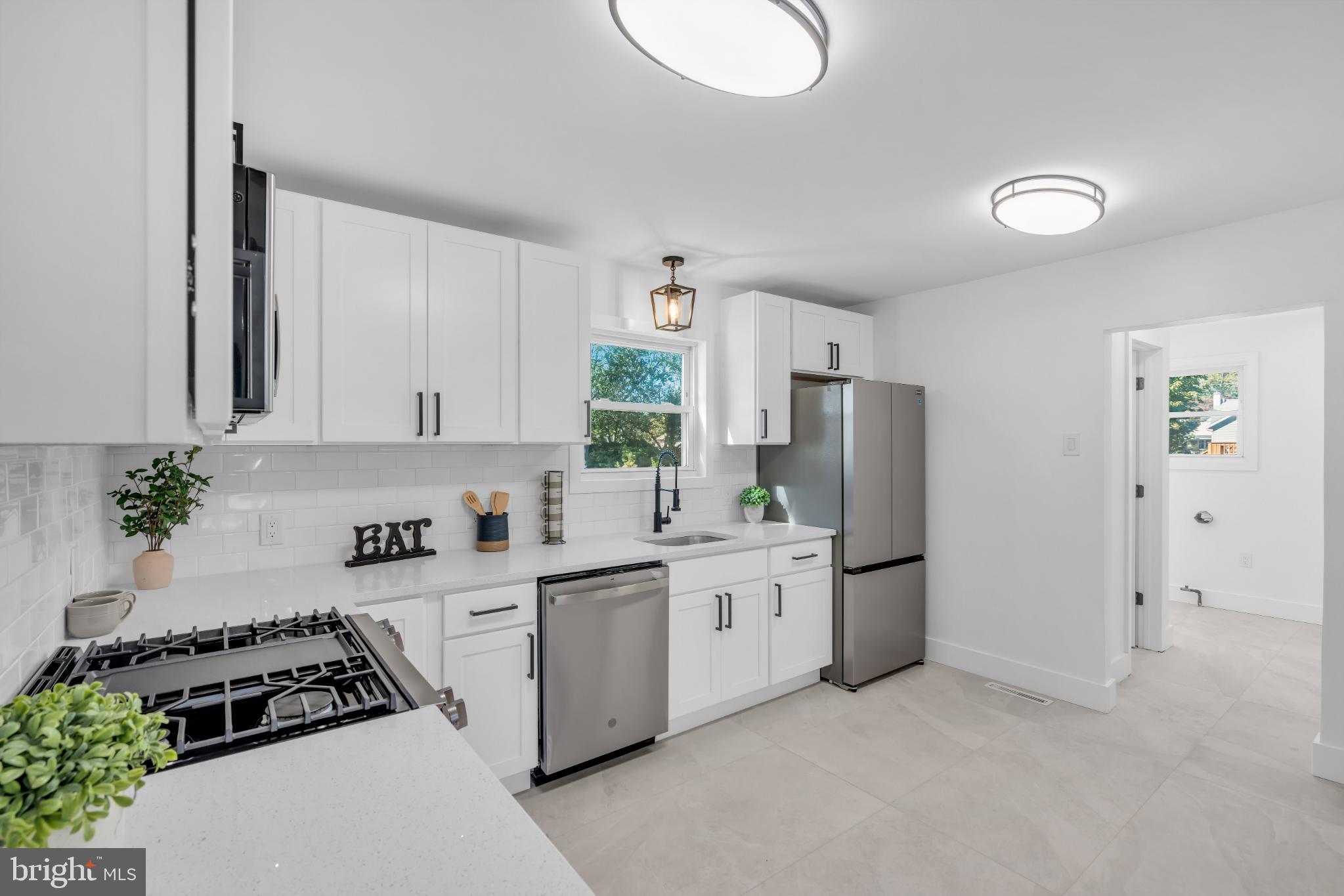 104 East Laurelton Avenue Maple Shade, NJ 08052 - Photo 10 of 37 a kitchen with stainless steel appliances a refrigerator sink and white cabinets
