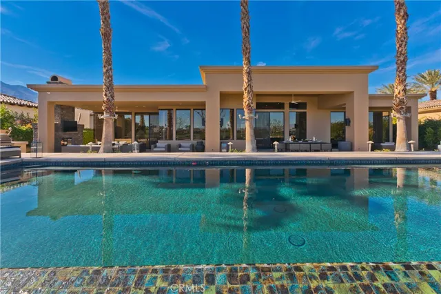 a dining room with chandelier and wooden floor