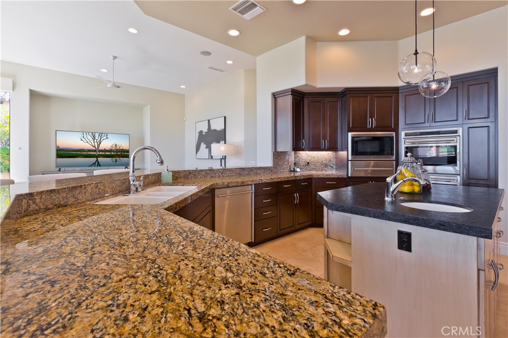 57780 Troon Way La Quinta, CA 92253 - Photo 27 of 67 a kitchen with stainless steel appliances granite countertop a sink a stove and a microwave