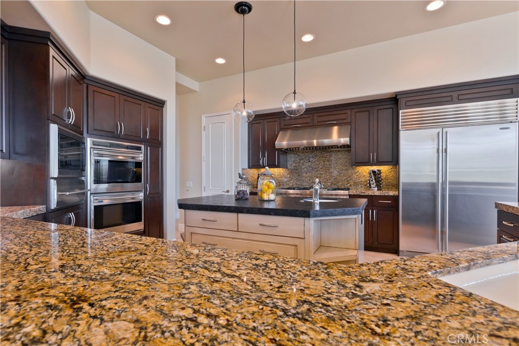 57780 Troon Way La Quinta, CA 92253 - Photo 29 of 67 a kitchen with stainless steel appliances kitchen island granite countertop a refrigerator stove and oven
