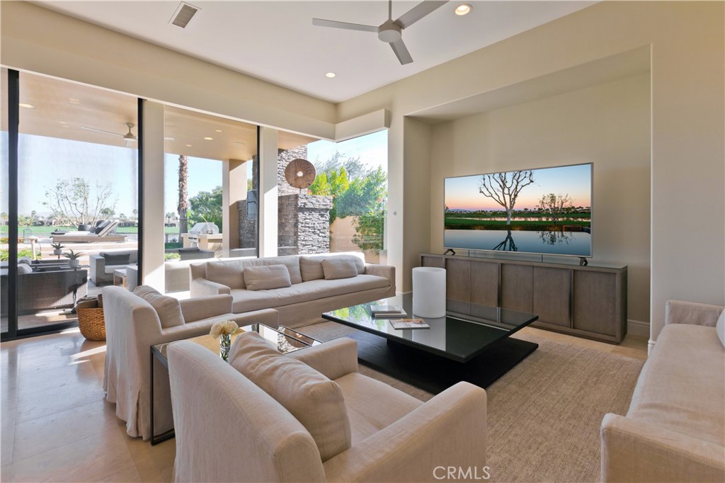 57780 Troon Way La Quinta, CA 92253 - Photo 33 of 67 a living room with furniture a floor to ceiling window and a flat screen tv