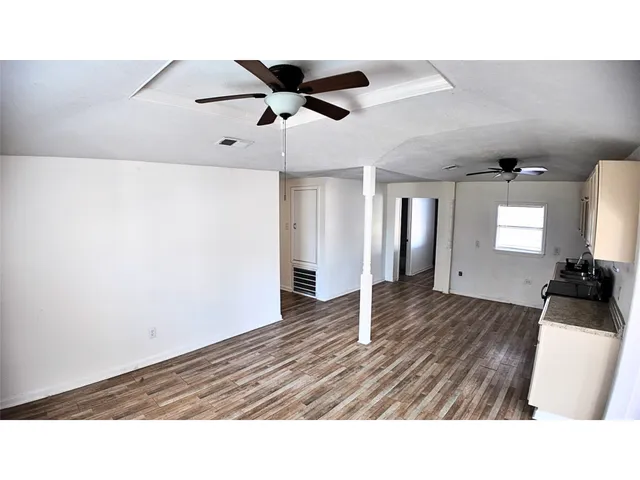 a living room with wooden floor and furniture