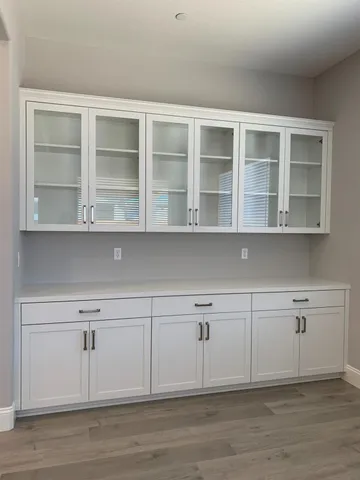 a view of white cabinets with wooden floor and cabinet