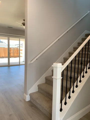 a view of staircase with wooden floor and white walls