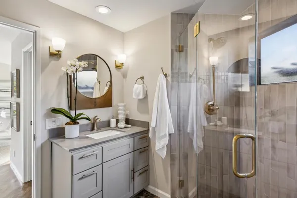 a bathroom with a double vanity sink mirror and shower