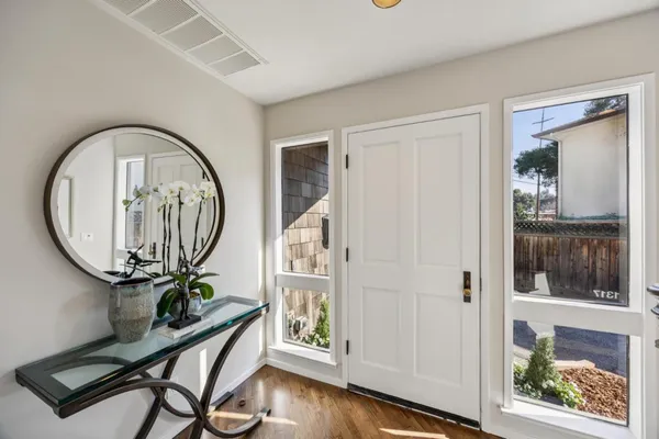 a view of a hallway with wooden floor and entryway