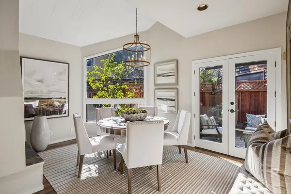 a dining room with furniture a chandelier and wooden floor