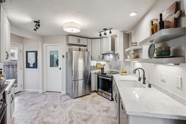 a kitchen with granite countertop a sink stainless steel appliances and cabinets