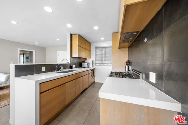 a large kitchen with stainless steel appliances a sink and a refrigerator