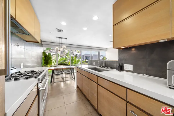 a kitchen with sink a stove and chairs