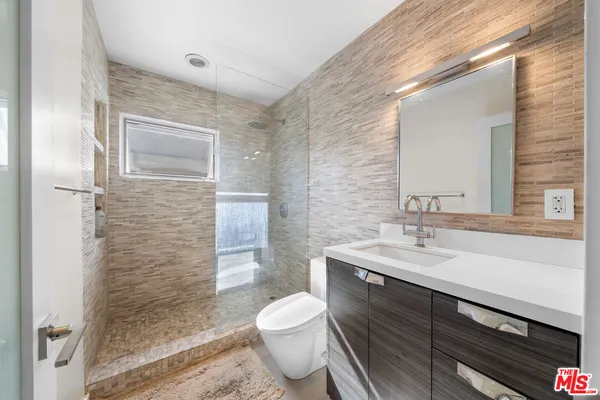 a bathroom with a sink a toilet and shower