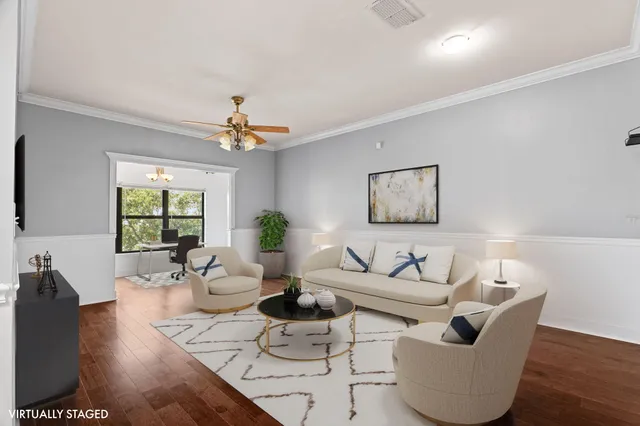 a living room with couches and a potted plant on a coffee table with wooden floor