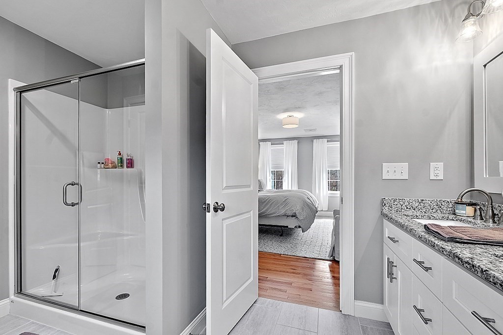 78 Hutchinson Road Sutton, MA 01590 - Photo 23 of 36 a en suite bathroom with a granite countertop sink a mirror and shower