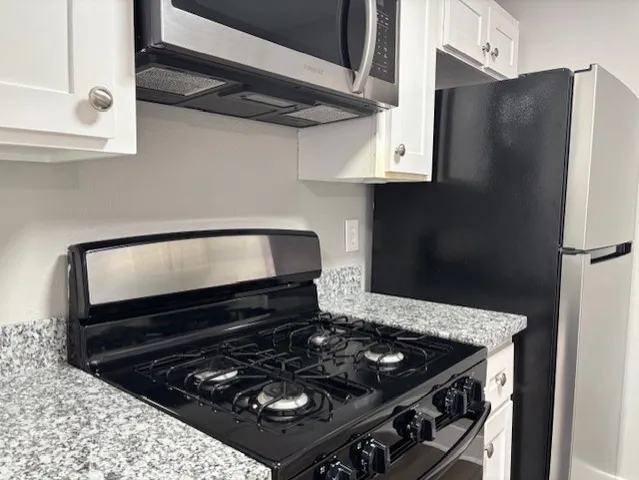 a black and white stove top oven sitting inside of a kitchen