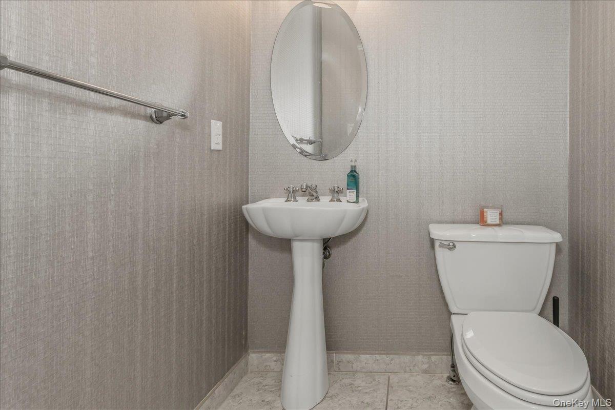263 James Street Franklin Square, NY 11010 - Photo 12 of 23 a bathroom with a sink a toilet and a mirror