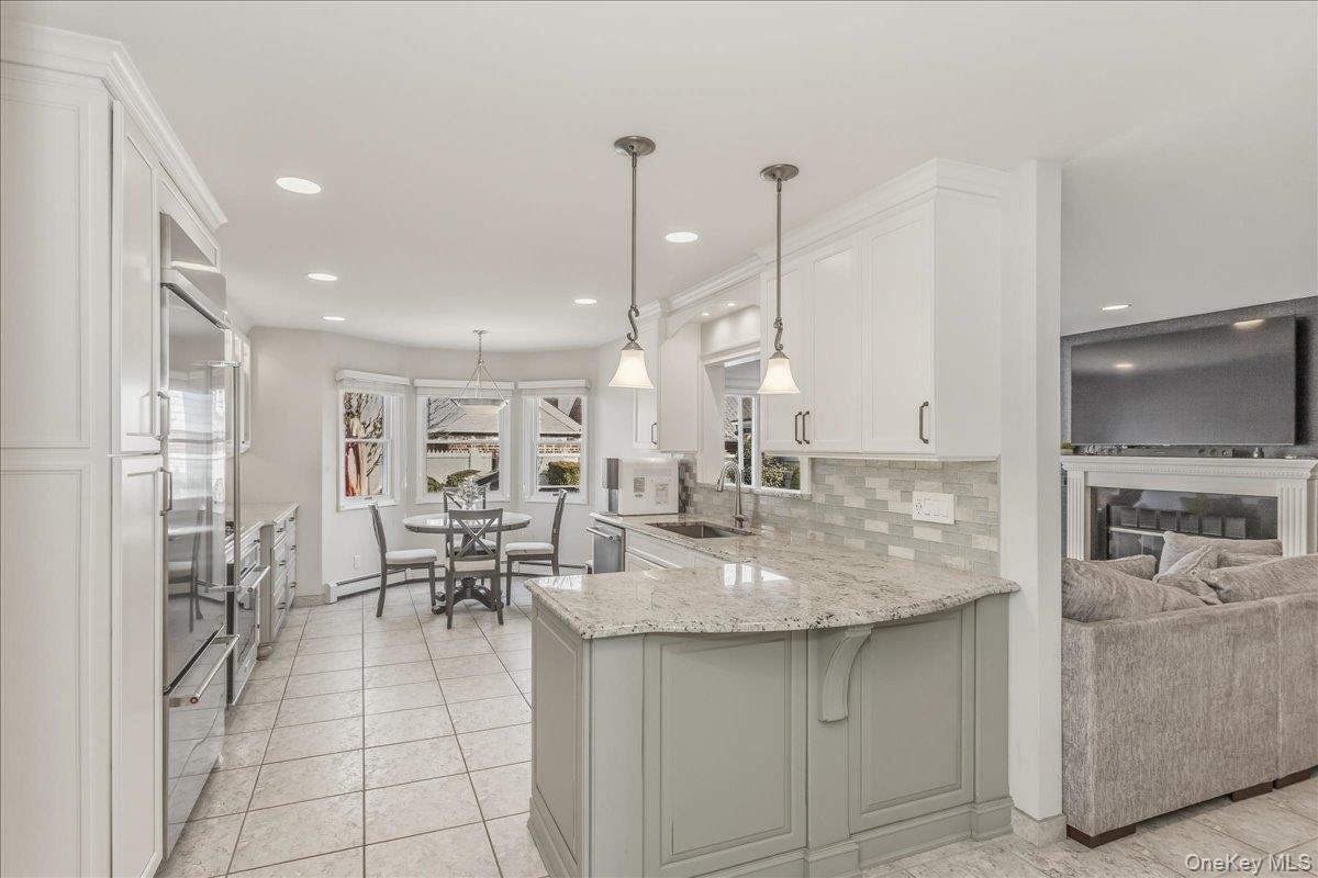 263 James Street Franklin Square, NY 11010 - Photo 4 of 23 a kitchen with stainless steel appliances kitchen island granite countertop a table chairs and a view of living room