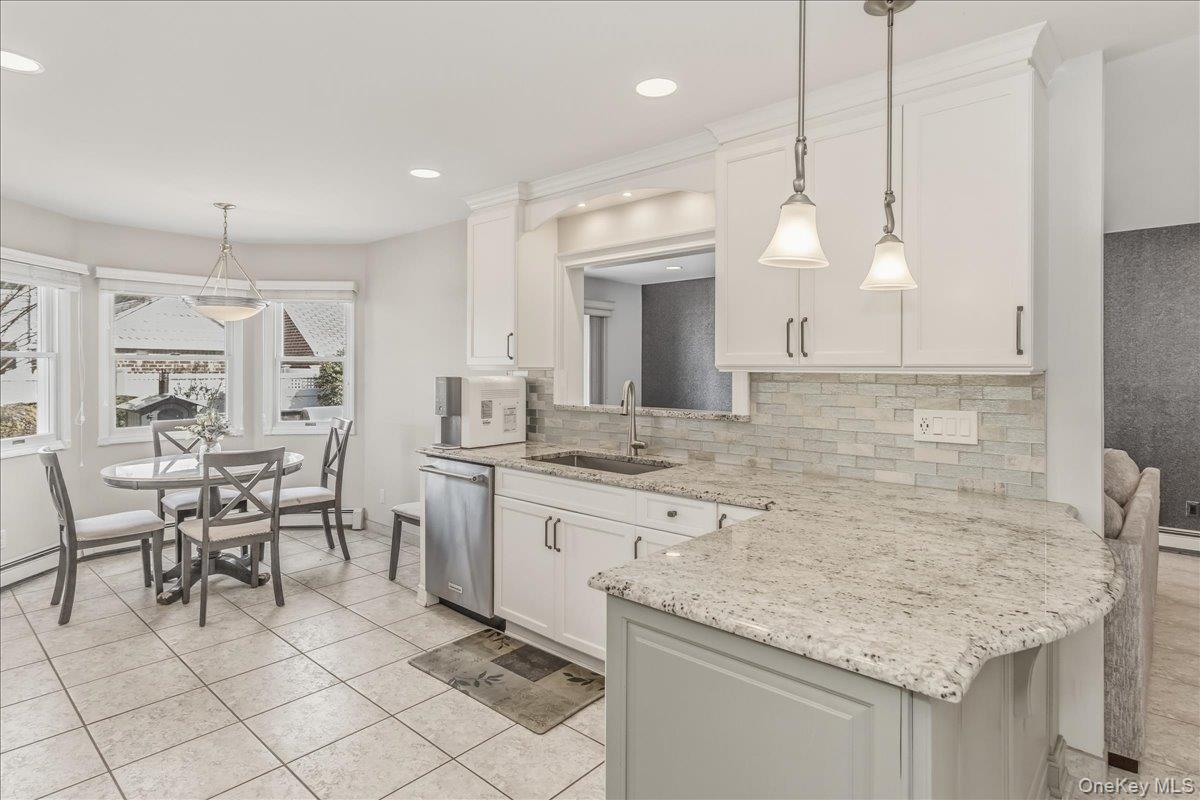 263 James Street Franklin Square, NY 11010 - Photo 8 of 23 a kitchen with a sink stools a counter space and cabinets