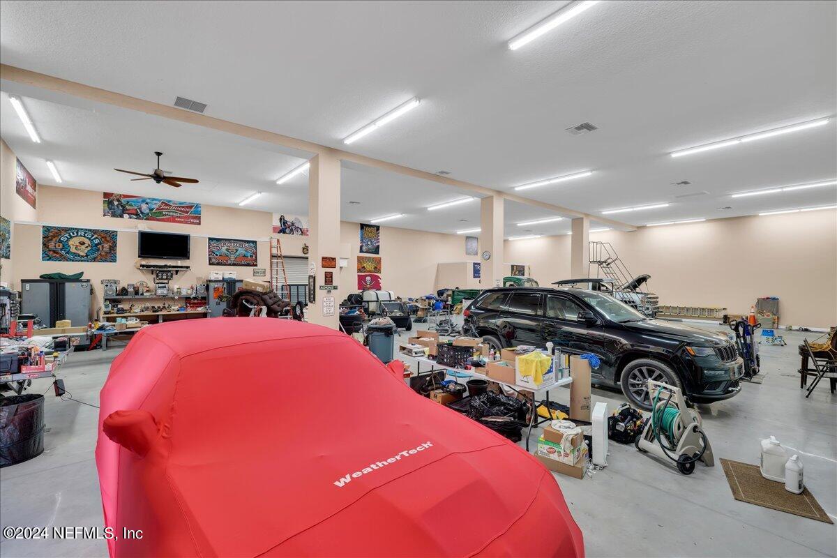 87359 Raddin Road Yulee, FL 32097 - Photo 54 of 80 a gym room with lots of furniture and a flat screen tv